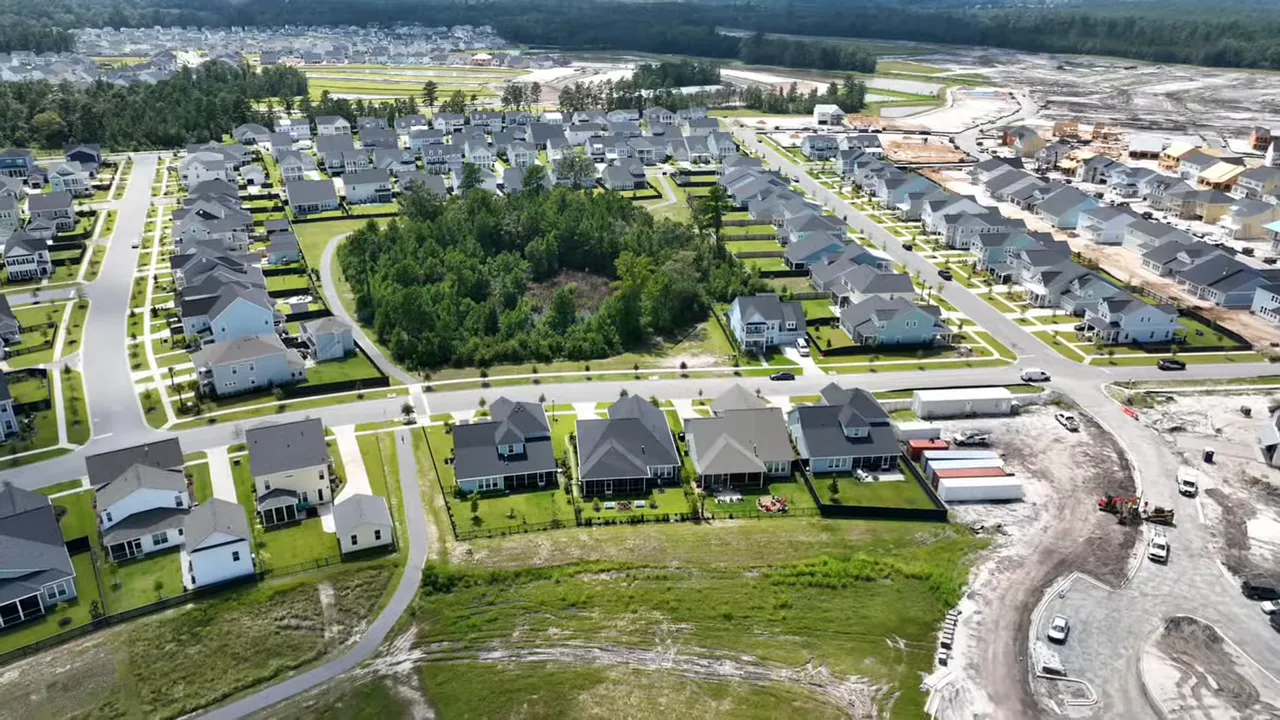 Aerial/drone photo of a suburban neighborhood with houses, yards, and roads highlighting lot sizes and layout