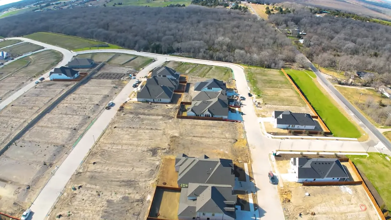 Aerial view of residential development with empty lots and completed houses.