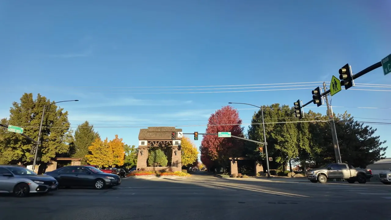 Roadway view toward the Paramount neighborhood entrance in Meridian, Idaho with vehicles and traffic lights