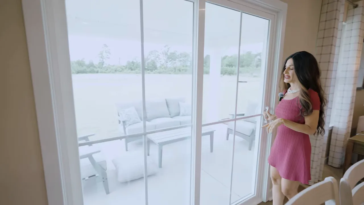 Sliding glass door leading to covered patio with outdoor chairs and table visible outside