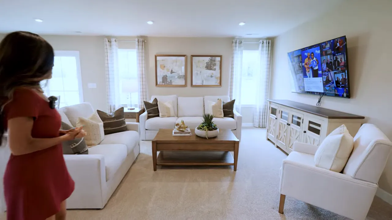 Living room with sofa loveseat coffee table accent chairs and television on the wall