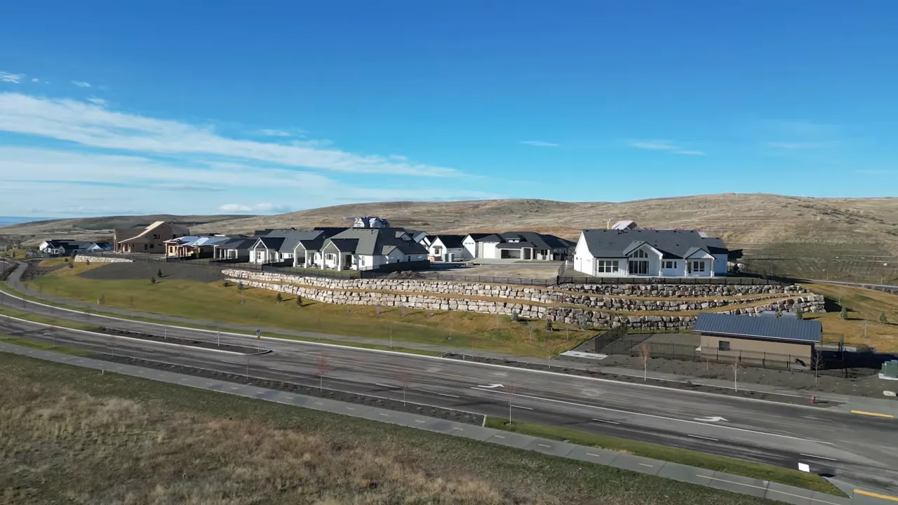 Wide aerial of the Glen Cara recreation area at Valnova showing terraced site, homes, roads and open hills