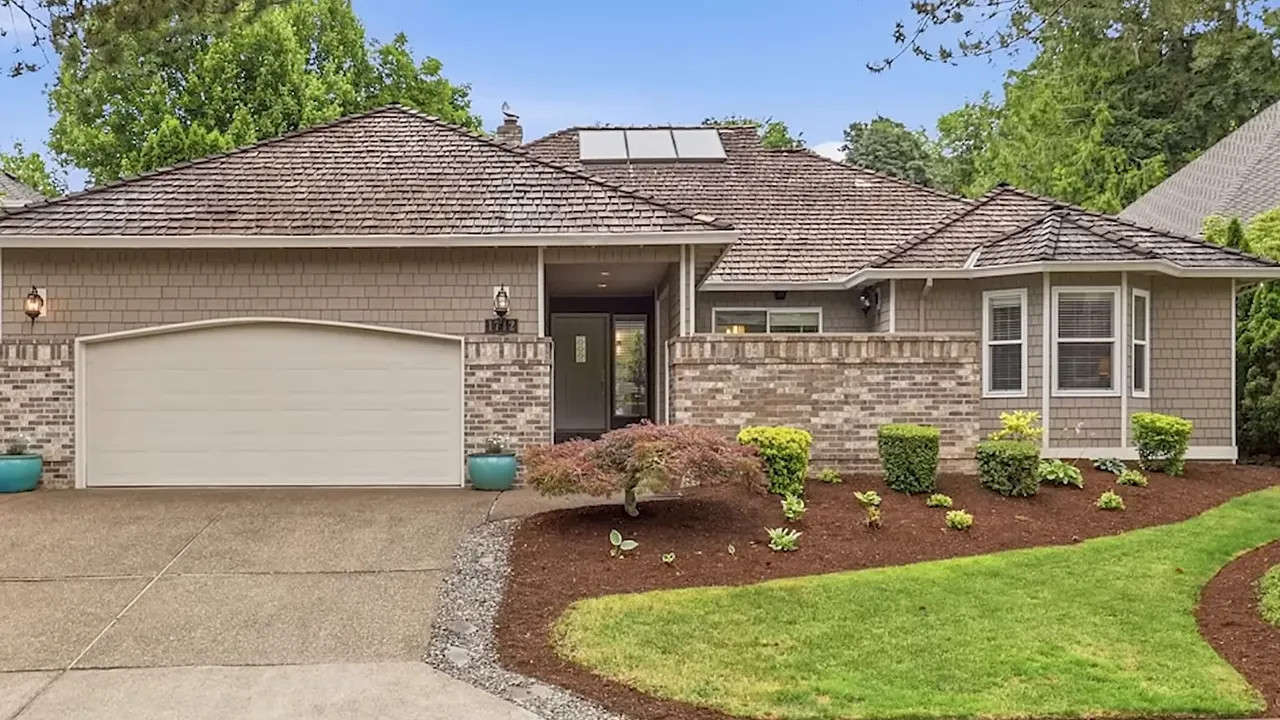 Single level suburban home with landscaped front yard and attached garage