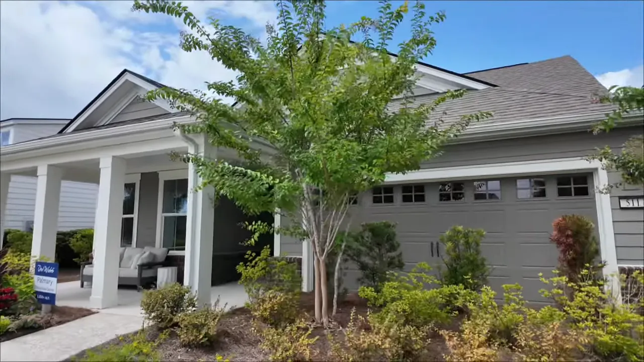 Exterior front view of a Del Webb Nexton Palmary model home with covered porch and garage.