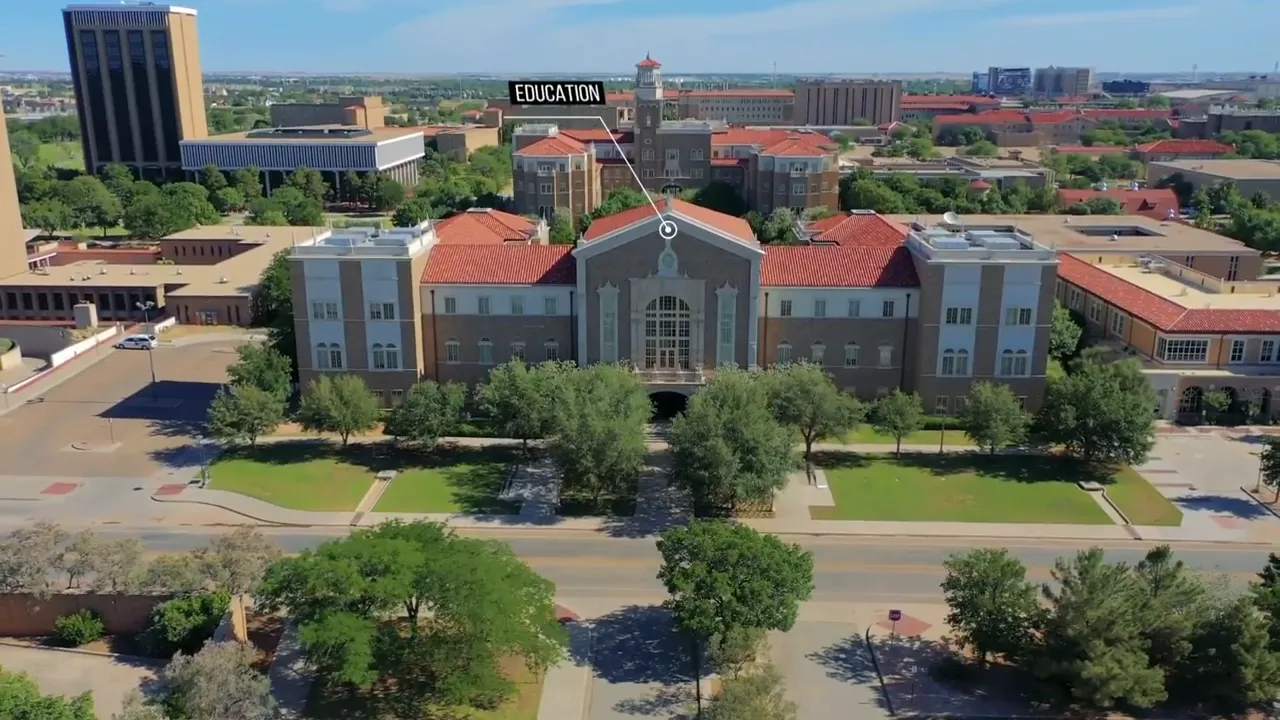 Aerial view of a university campus building labeled 'Education' with trees and surrounding campus buildings
