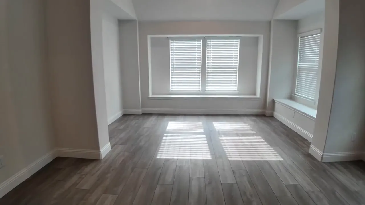 Primary bedroom sitting area with large windows and built in bench seating