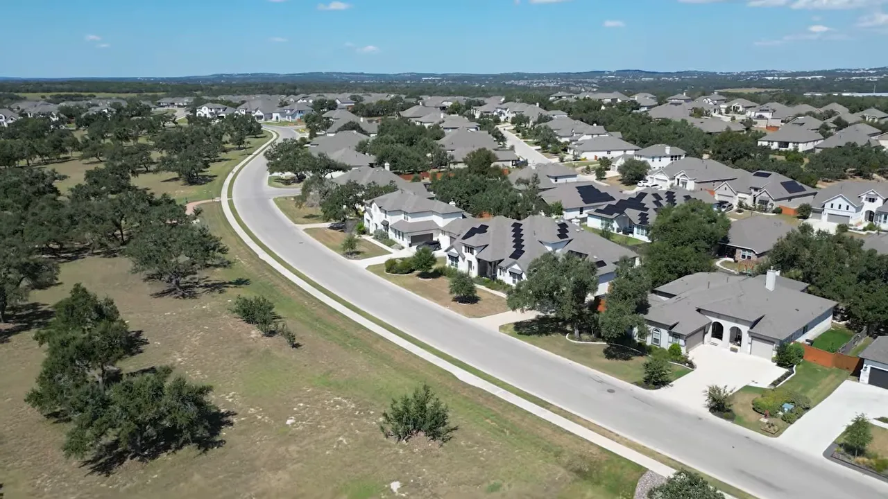 Aerial view of an Austin suburb with a winding road and residential homes