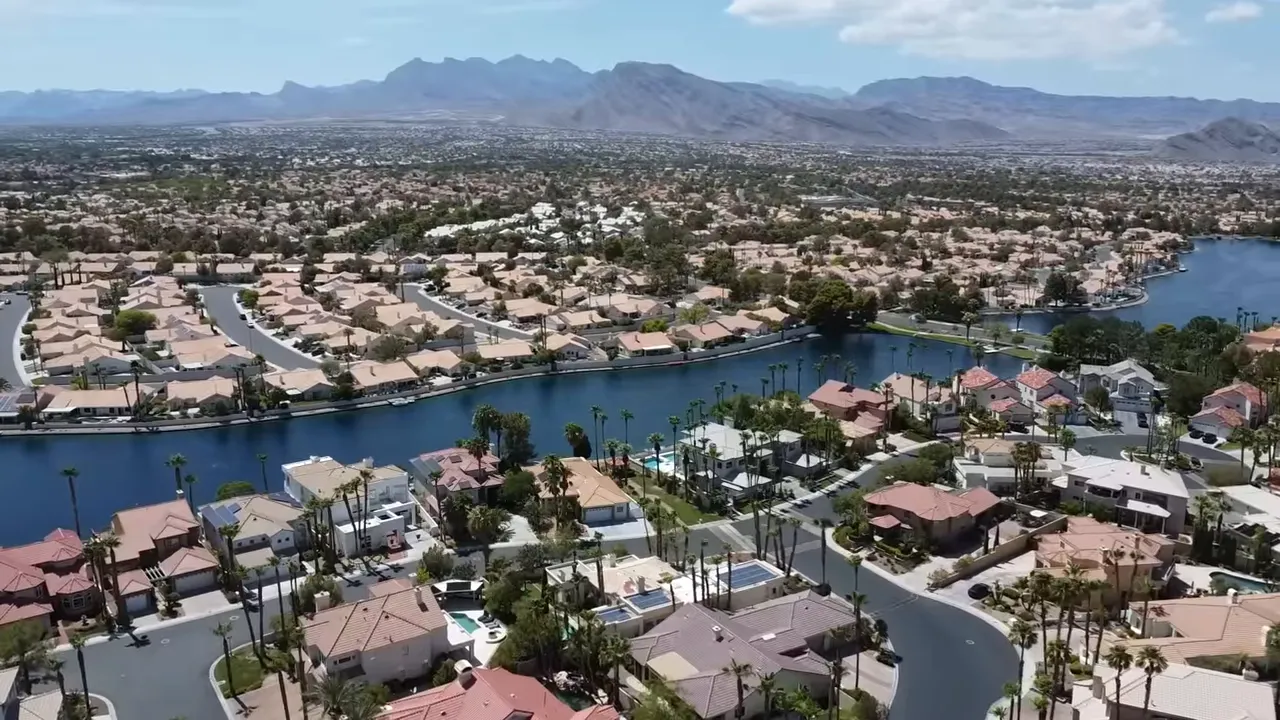 Aerial view of homes around a lake with home price text