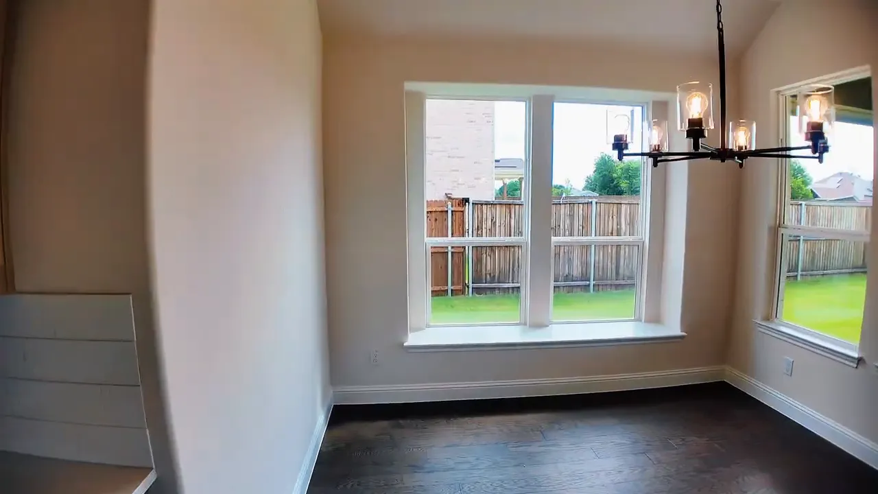 Dining area window seat with large windows overlooking backyard