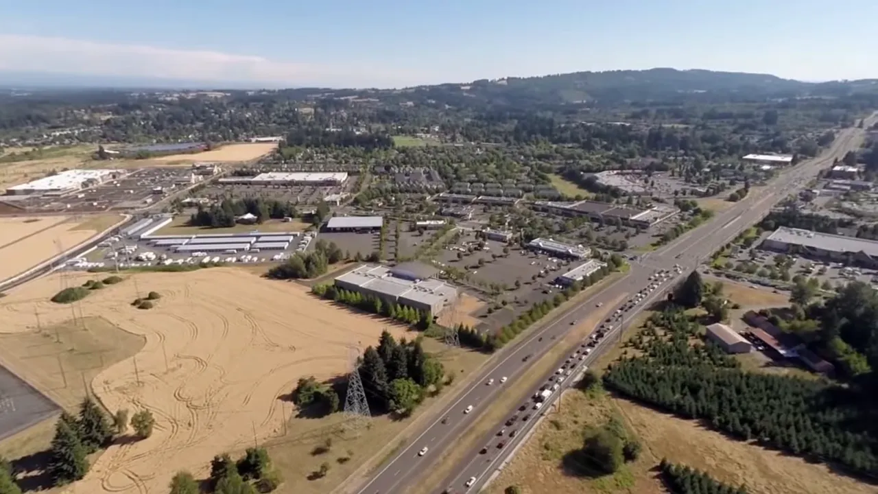 Aerial view of highway, fields, neighborhoods, and hills near Sherwood