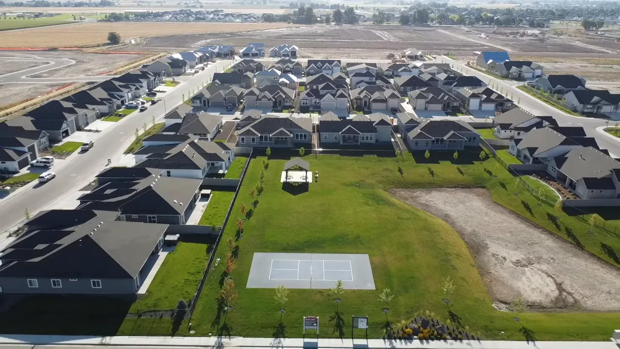 Aerial view of newer subdivision surrounding a central green space and sport court