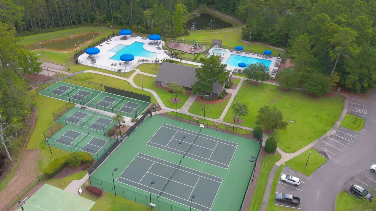 Aerial view of community pool tennis courts and clubhouse
