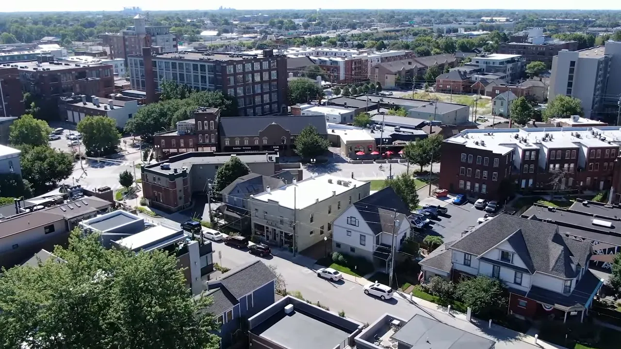 High-resolution drone photo of the Bottle Works District showing mixed-use buildings, streets, and nearby residential blocks