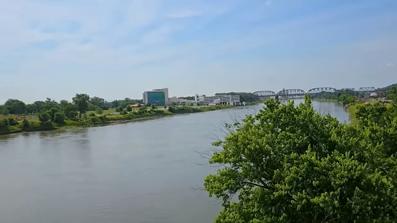 Omaha riverfront with river, trees, buildings and a bridge in the distance