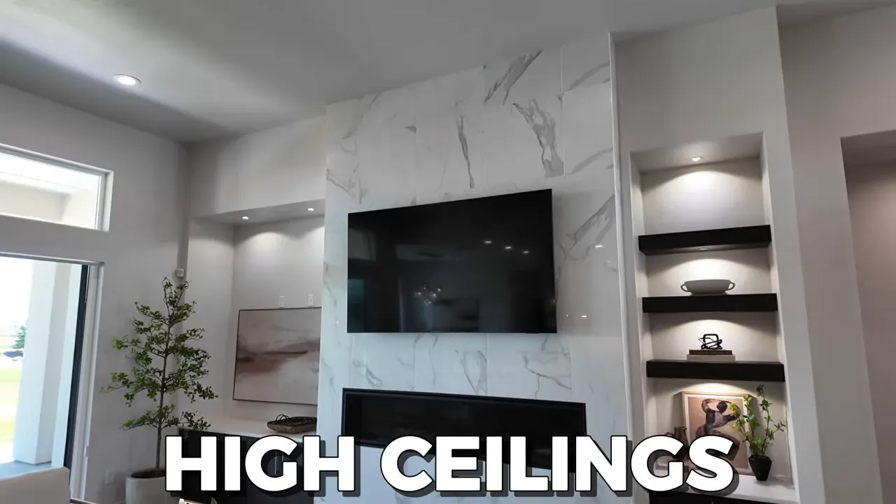 Tall marble-look fireplace wall with television, linear fireplace and built-in shelves