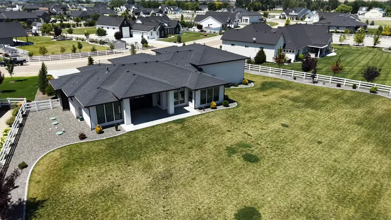 Aerial view of large grassy backyard behind single story home
