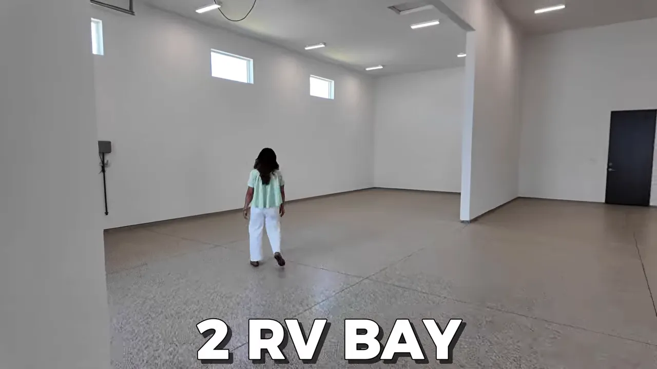 Wide interior view of two deep RV garage bays with epoxy floor