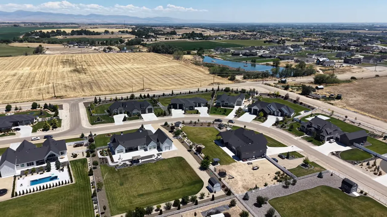 Aerial view of homes beside open fields and water in Middleton