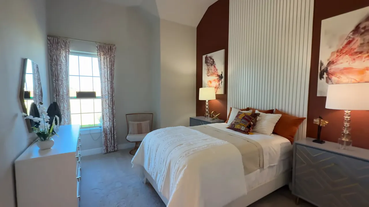 Secondary bedroom with bed, vaulted ceiling, window and bedside tables in the Catalina model