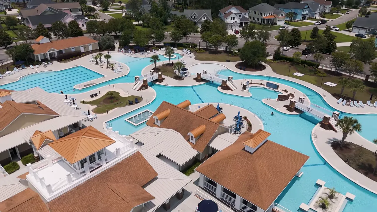 Overhead view of winding community pool with central clubhouse buildings