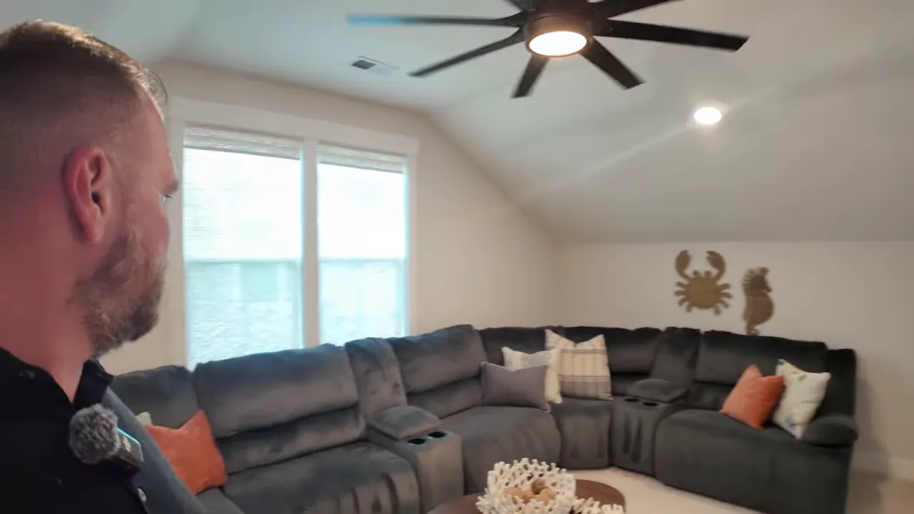 Large upstairs bonus room with sectional sofa, coffee table, and ceiling fan