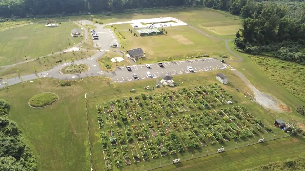Aerial view of community park with garden plots parking lot and open fields