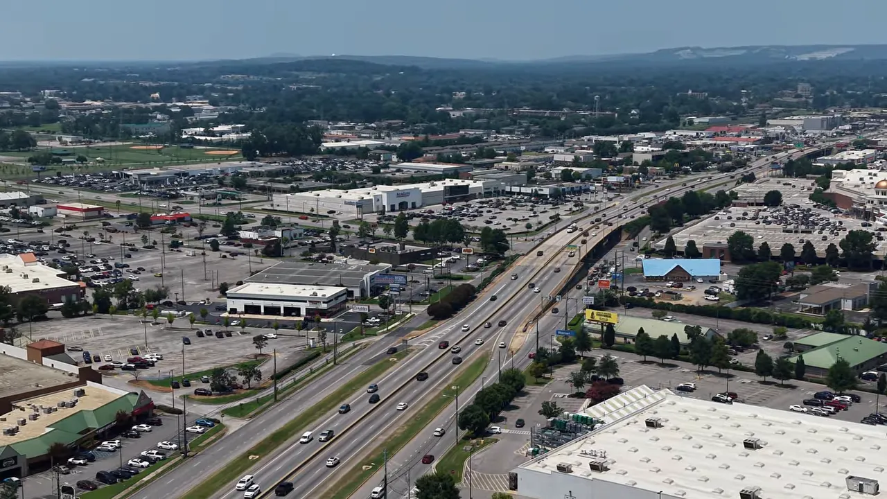 Aerial view of a major road corridor with commercial buildings and traffic