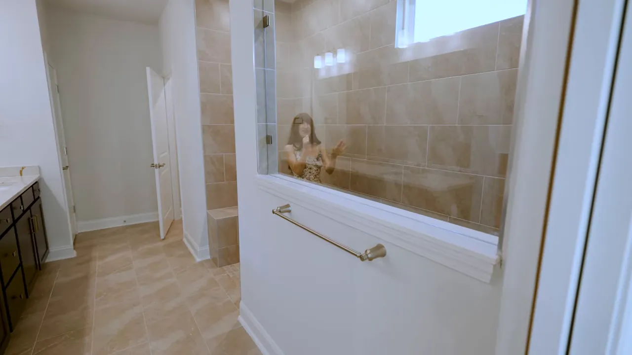 Zero-entry no-slip primary shower with tiled walls and grab bar in a new construction home