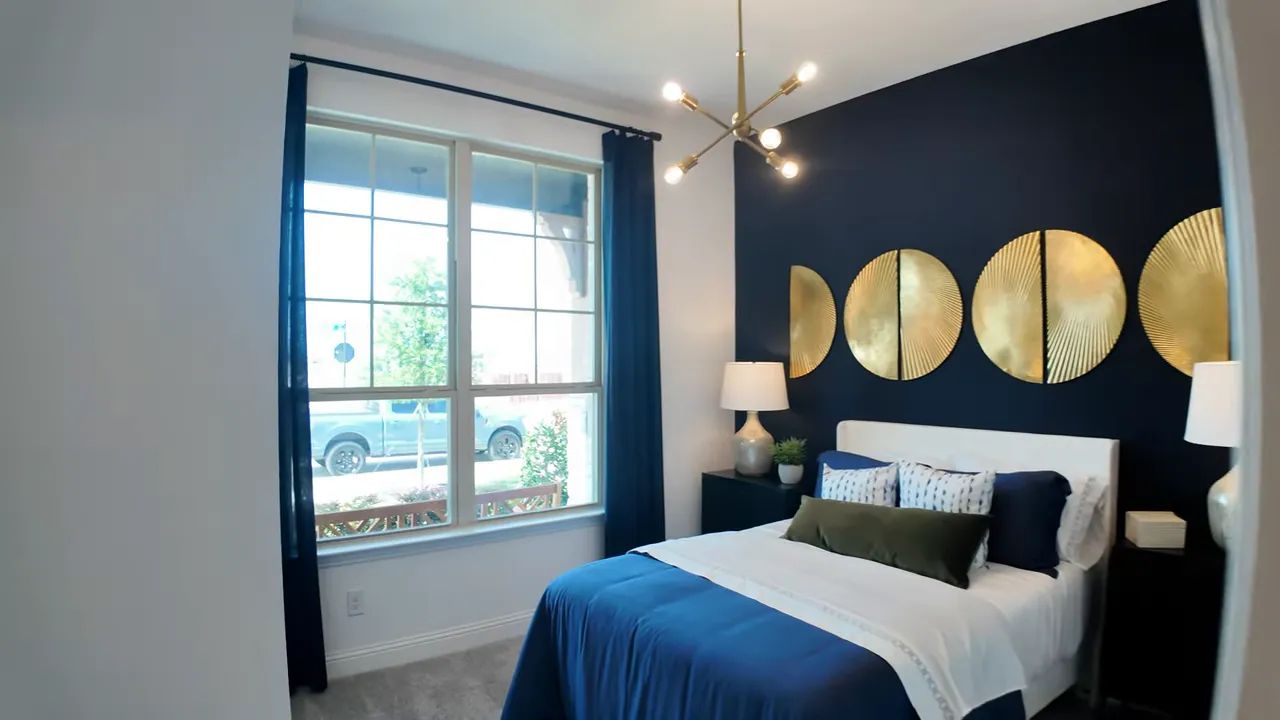 front bedroom with blue accent wall gold wall decor and window