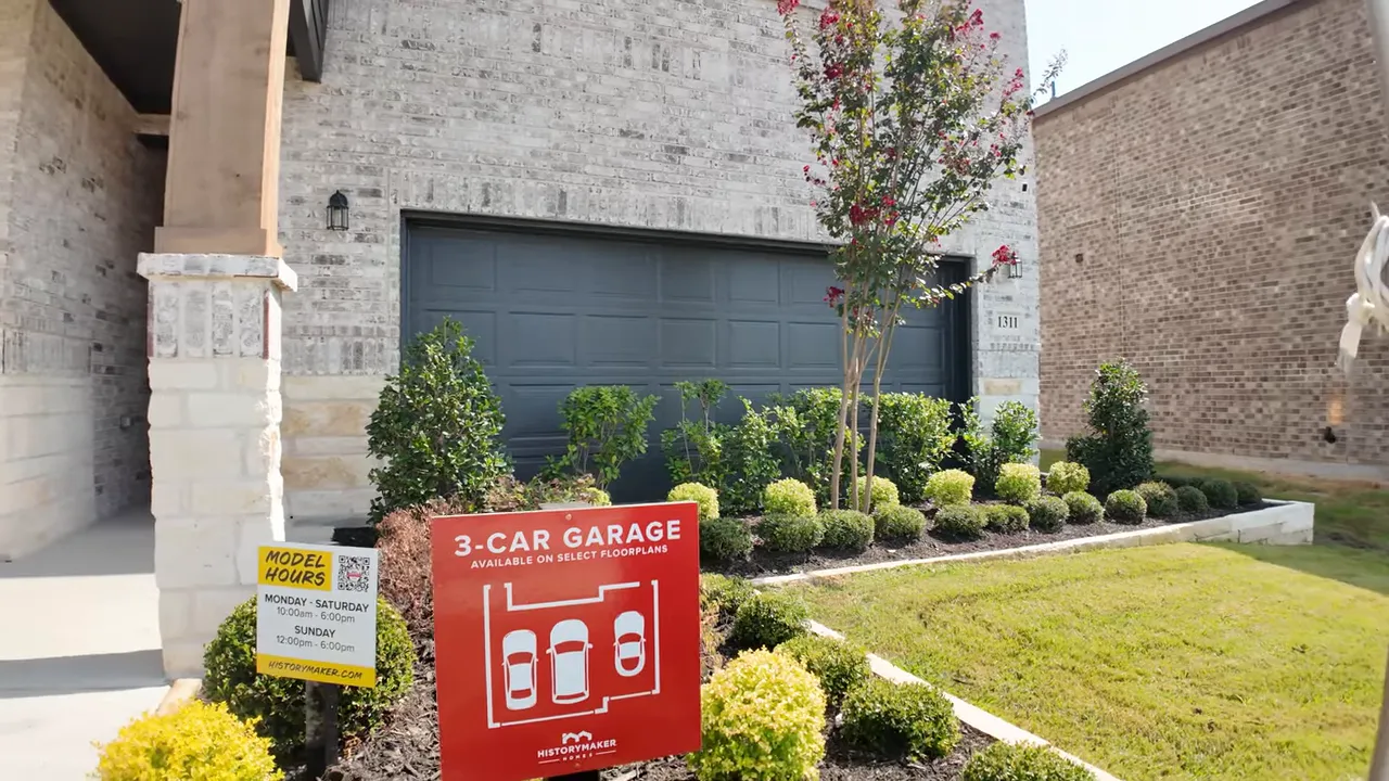 red 3 car garage sign in front of model home garage and landscaping