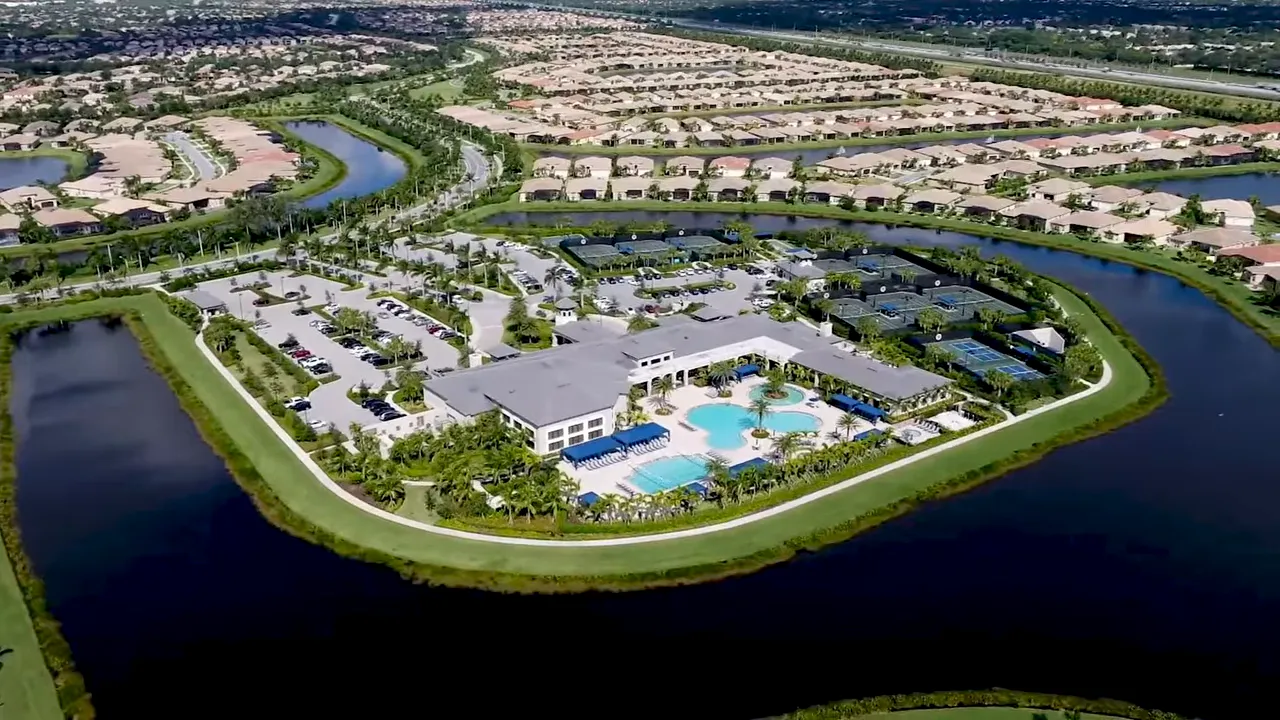 Aerial view of Valencia-style 55+ community amenities including clubhouse, pools, and courts