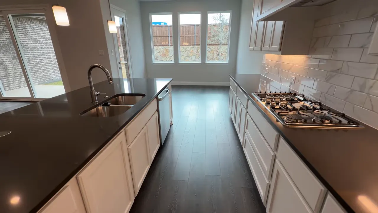 open kitchen with island sink and five-burner gas range looking toward dining area
