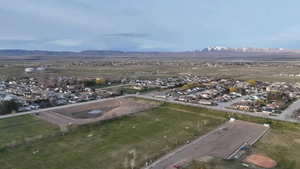 Aerial view over Mountain Home Idaho with open fields, neighborhoods, and distant mountains