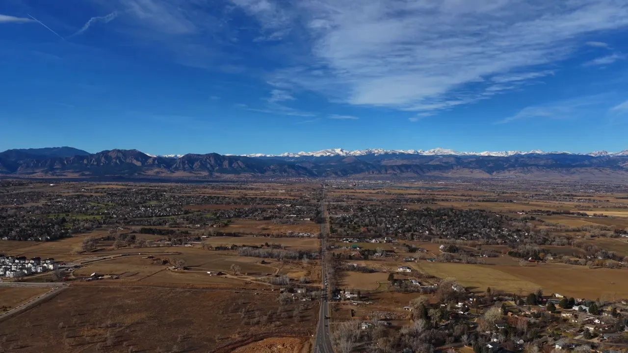 Wider aerial view of Lafayette Colorado with established neighborhoods and mountain backdrop