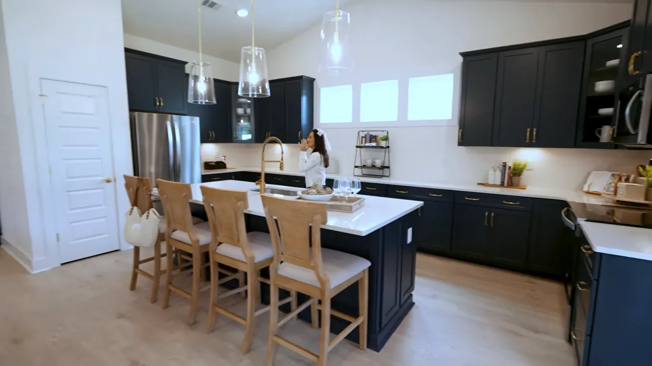 Open concept kitchen with dark cabinets, pendant lights, and island seating in a new construction home