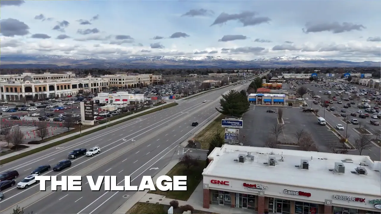Aerial view of The Village shopping area in Meridian, Idaho with retail storefronts and parking along a main road