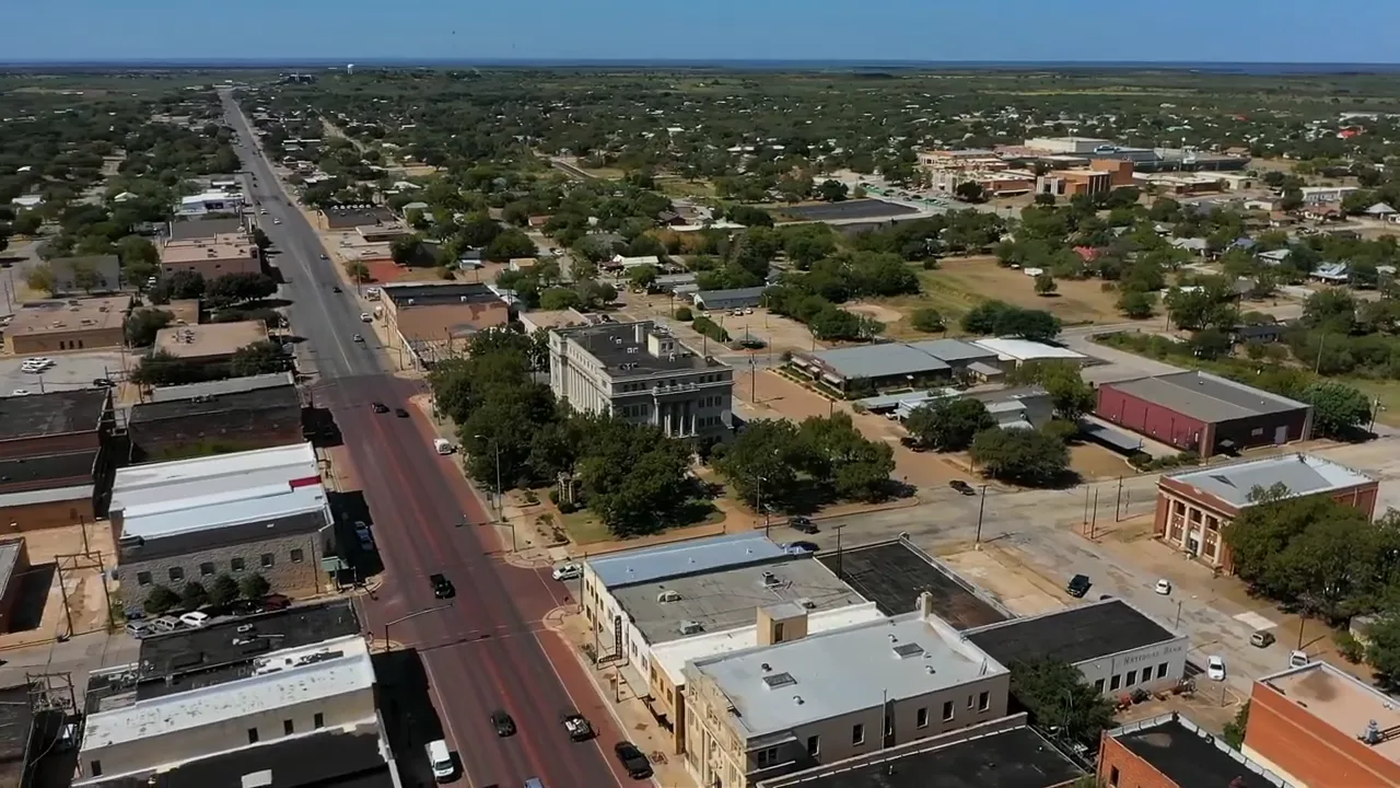 Aerial view of a small Central Texas town showing main street, buildings, and surrounding neighborhoods.
