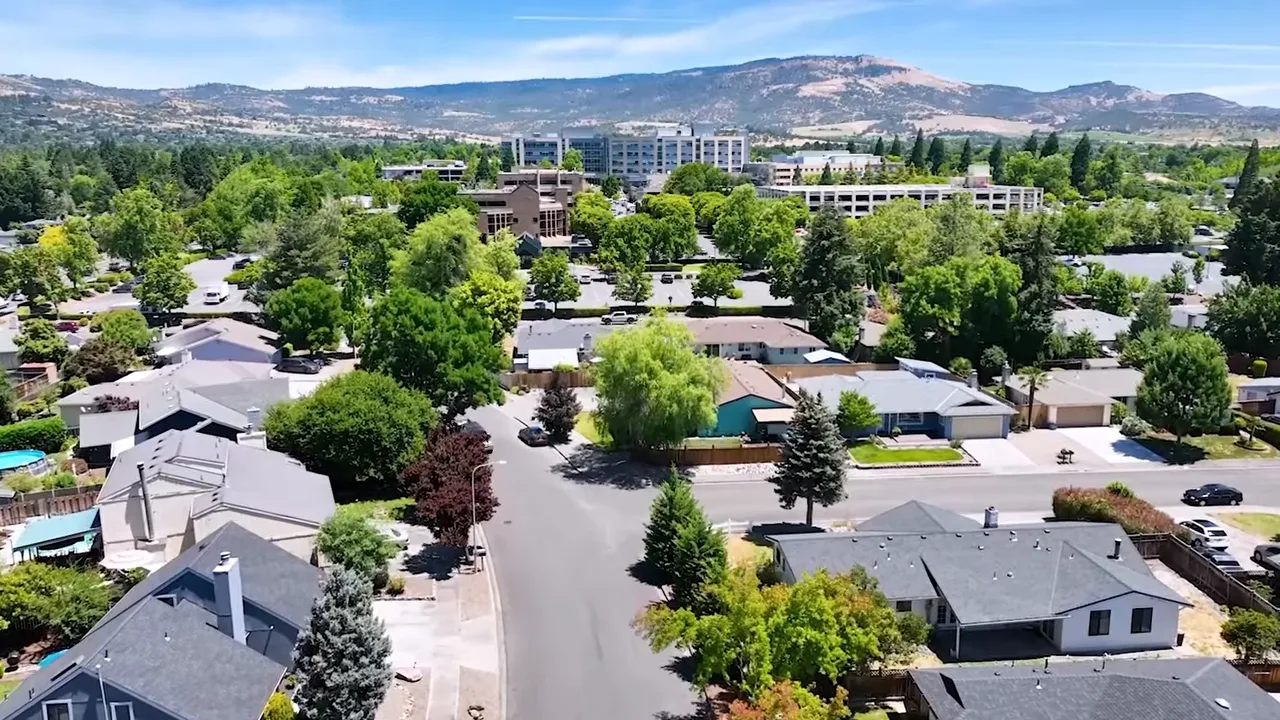 Aerial view of homes, downtown buildings, and surrounding hills in Southern Oregon