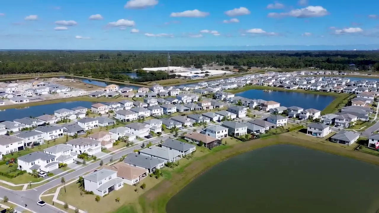 Aerial view of a master-planned active adult community with homes and a lake