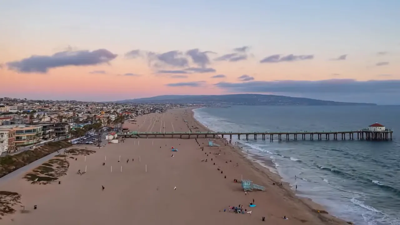 Aerial view of Manhattan Beach coastline with pier and shoreline at sunset