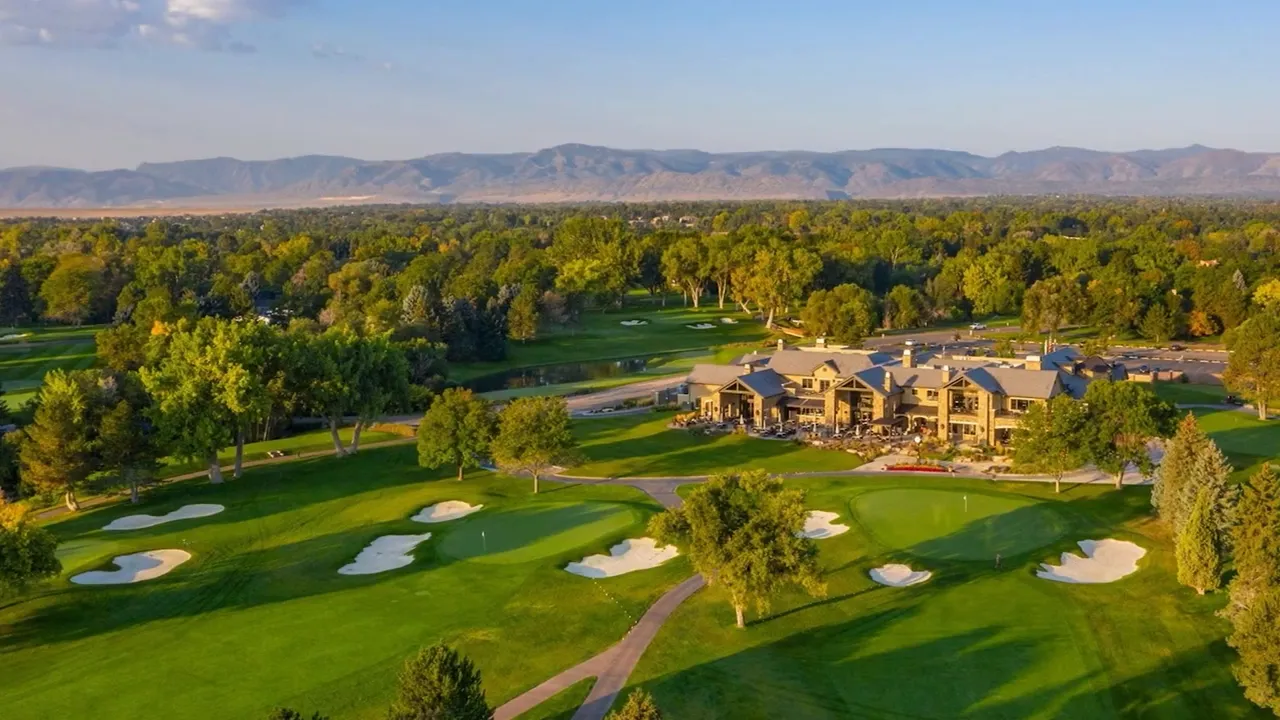 Aerial view of green golf course with estate homes