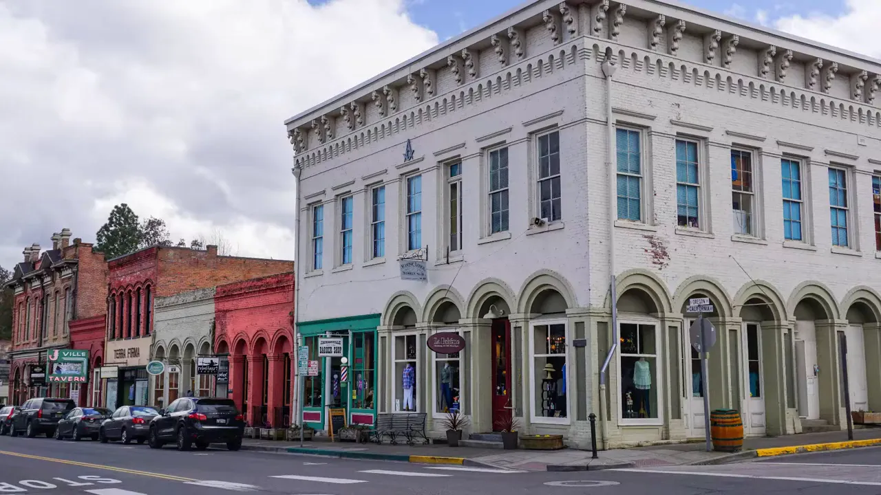 historic downtown street with ornate white corner building and storefronts