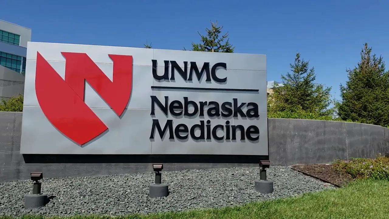UNMC Nebraska Medicine entrance sign with red logo and landscaping