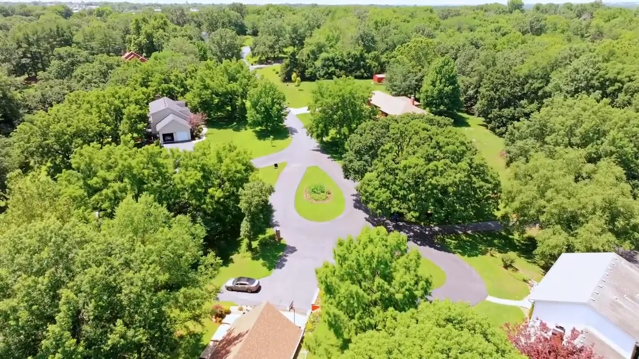 Aerial view of a circular neighborhood street surrounded by dense trees