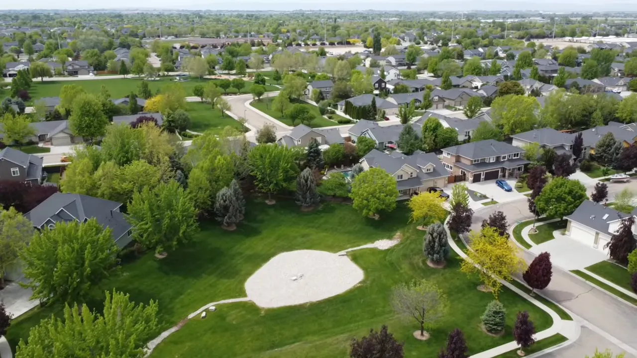 Aerial view of planned suburban neighborhood with homes and tree-lined streets in Idaho