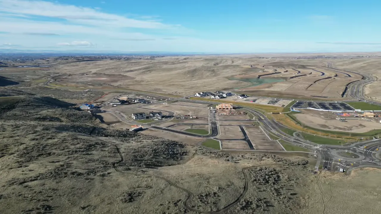 Aerial view of roads and homes under construction across open land