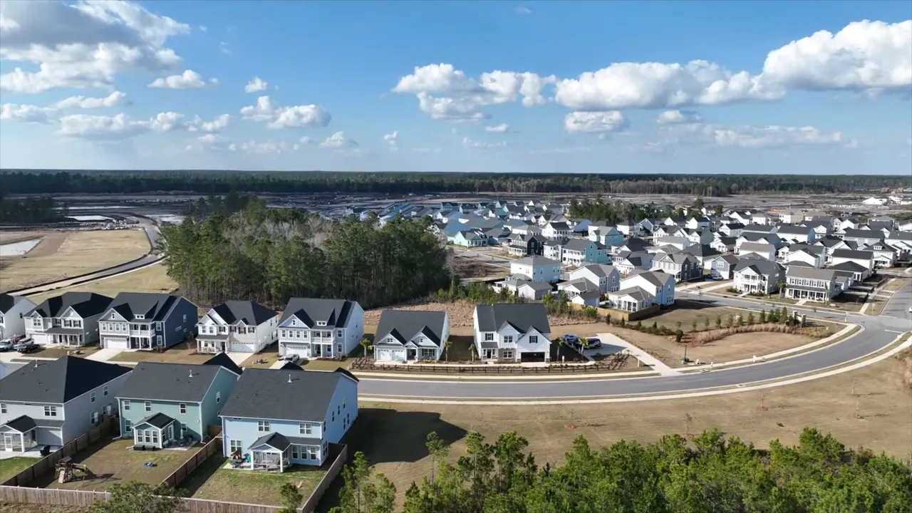 Wide aerial drone shot of a Summerville neighborhood with houses, roads, and trees