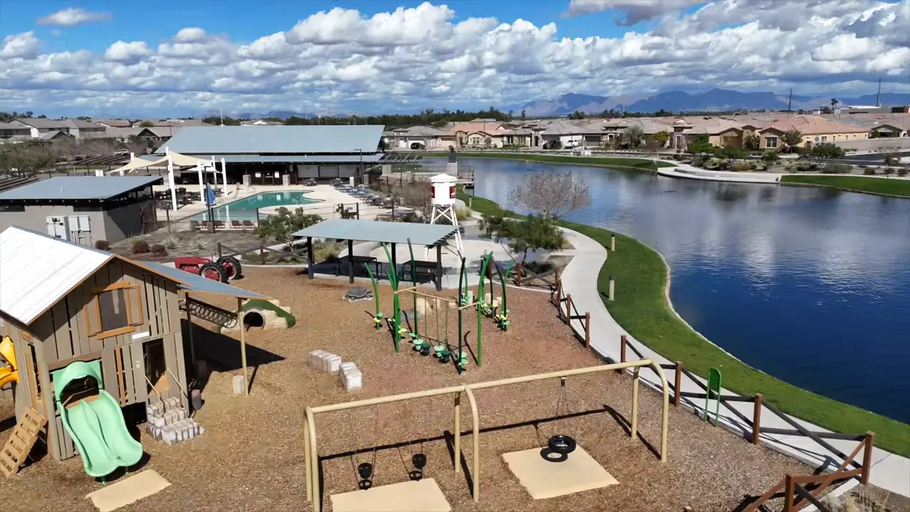 Farm themed playground beside a community lake and walking path