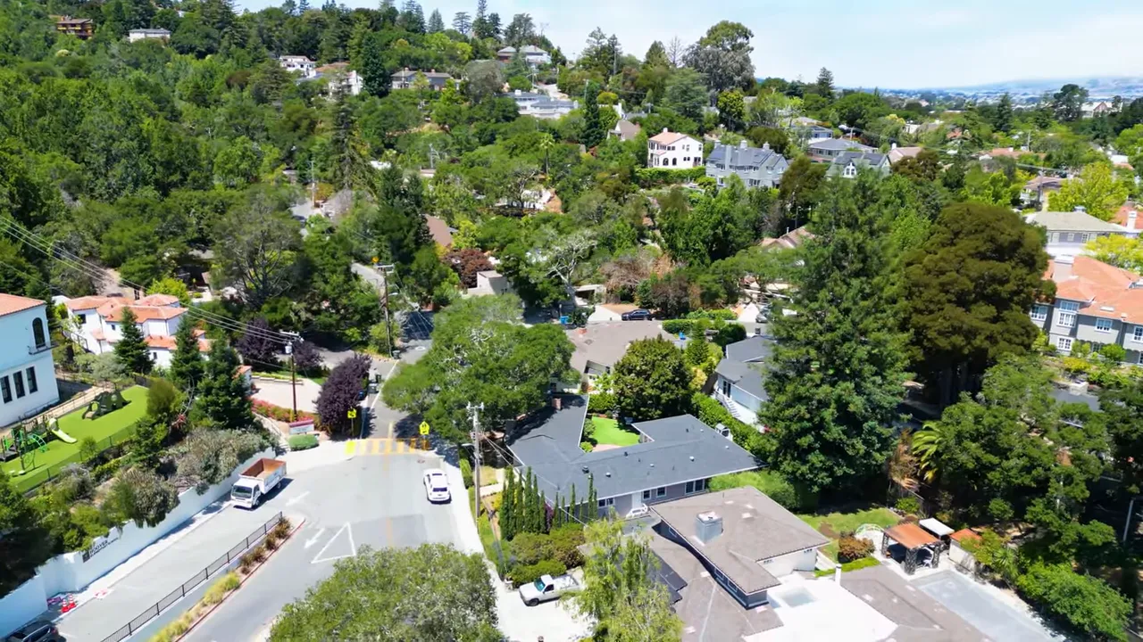 high-resolution aerial view of mixed hill-and-flat residential neighborhood with trees and homes
