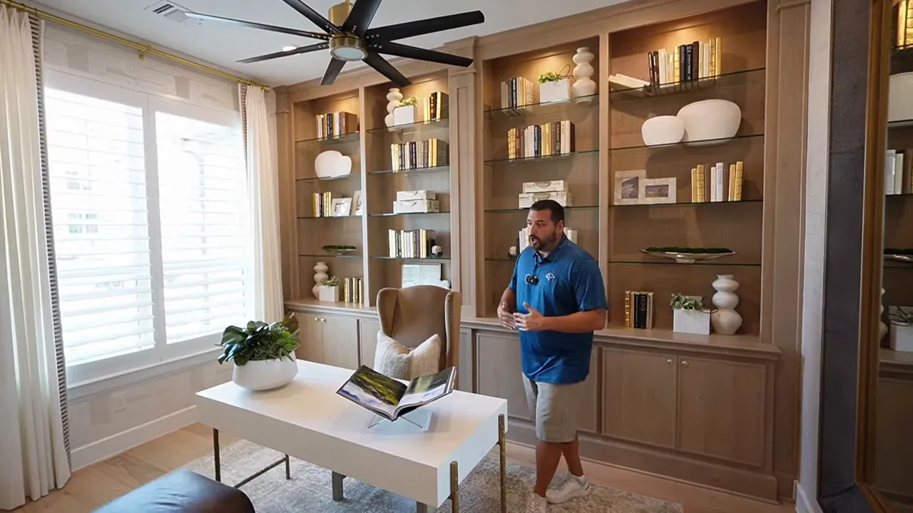 Home office built-ins with glass shelves and LED puck lighting